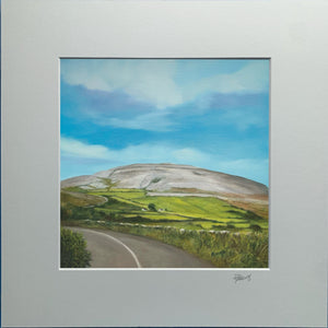Framed painting of a landscape with a road and green fields under a blue sky.