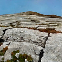 Load image into Gallery viewer, Rugged mountain landscape with rocky terrain and sparse vegetation under a clear blue sky.