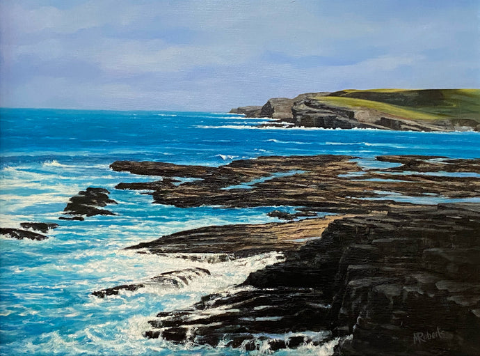 Coastal scene with rocky cliffs and blue ocean under a cloudy sky